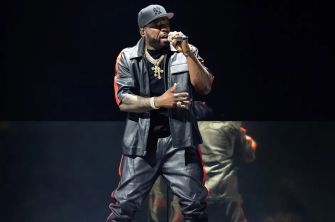 50 Cent performing on stage during a concert.