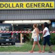 Two women walk by the Dollar General store, which is cordoned off with police tape following a shooting incident. Two women walk by the Dollar General store, which is cordoned off with police tape following a shooting incident.