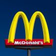 McDonald's logo with bright yellow arches against a blue sky. McDonald's logo with bright yellow arches against a blue sky.