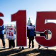 Activists hold signs calling for Congress to includes a $15 federal minimum wage in a a COVID-19 relief bill outside the U.S. Capitol complex in Washington on Feb. 25, 2021.