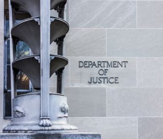 Signage of the Department of Justice on a building exterior.