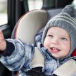 A smiling toddler in a winter coat and knitted hat sits in a car seat, pointing with enthusiasm. A smiling toddler in a winter coat and knitted hat sits in a car seat, pointing with enthusiasm.