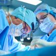 Two surgeons performing a medical procedure in an operating room. Two surgeons performing a medical procedure in an operating room.