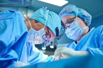Two surgeons performing a medical procedure in an operating room.