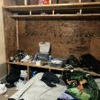 A cluttered and unsanitary living space with a makeshift bed, disorganized personal items, and overall poor conditions at a dairy farm. A cluttered and unsanitary living space with a makeshift bed, disorganized personal items, and overall poor conditions at a dairy farm.
