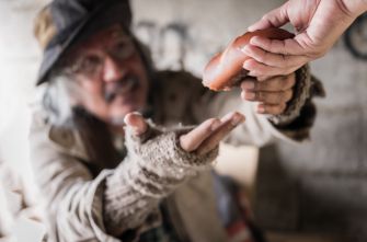 A person receiving food from another individual, highlighting the act of sharing and charity.
