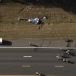 Aerial view of a helicopter crash site alongside an interstate highway, with emergency responders at the scene. Aerial view of a helicopter crash site alongside an interstate highway, with emergency responders at the scene.