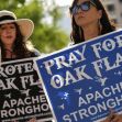 Two women holding signs supporting the protection of Oak Flat, with one sign stating "Pray for Oak Flat" and the other reading "Protect Oak Flat." Two women holding signs supporting the protection of Oak Flat, with one sign stating "Pray for Oak Flat" and the other reading "Protect Oak Flat."