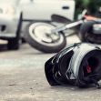 A motorcycle helmet on the ground near an accident scene, with a car and motorcycle in the background. A motorcycle helmet on the ground near an accident scene, with a car and motorcycle in the background.
