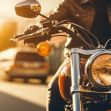 Close-up of a motorcycle with a rider in a leather jacket, highlighting the bike's headlight and signal in a sunlit urban setting. Close-up of a motorcycle with a rider in a leather jacket, highlighting the bike's headlight and signal in a sunlit urban setting.