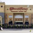 Exterior view of a Cheesecake Factory restaurant featuring outdoor seating and signage. Exterior view of a Cheesecake Factory restaurant featuring outdoor seating and signage.