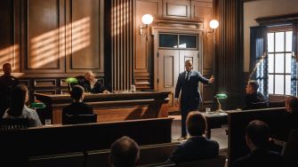 A courtroom scene depicting a legal discussion involving a judge, lawyers, and audience members.