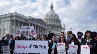 Protesters holding signs in support of TikTok in front of the U.S. Capitol building.