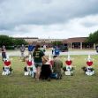A group of people memorializing victims of the Santa Fe High School shooting, with crosses and flowers displayed in a field outside the school building. A group of people memorializing victims of the Santa Fe High School shooting, with crosses and flowers displayed in a field outside the school building.