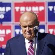 Rudy Giuliani speaking at a press conference with Trump campaign signage in the background. Rudy Giuliani speaking at a press conference with Trump campaign signage in the background.