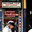 A storefront displaying signs related to notary services, immigration, and income tax. A storefront displaying signs related to notary services, immigration, and income tax.