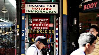 A storefront displaying signs related to notary services, immigration, and income tax.