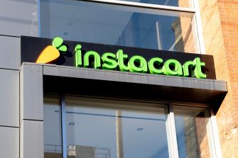 Instacart storefront sign displaying the logo with a stylized carrot and the company's name in green letters.