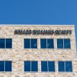 Signage of the Keller Williams Realty office building against a clear blue sky. Signage of the Keller Williams Realty office building against a clear blue sky.