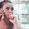 A worried woman talking on the phone, appearing distressed or anxious. A worried woman talking on the phone, appearing distressed or anxious.