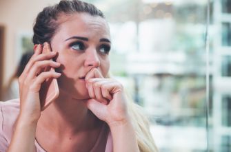 A worried woman talking on the phone, appearing distressed or anxious.
