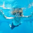 A man with long hair swimming underwater, reaching out with his hands. A man with long hair swimming underwater, reaching out with his hands.