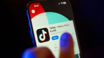 A close-up of a smartphone displaying the TikTok app, highlighting its logo and features.