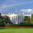 The White House building with a clear blue sky and well-maintained gardens in the foreground. The White House building with a clear blue sky and well-maintained gardens in the foreground.