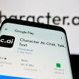 Screenshot of the Character.AI app interface on a smartphone, with the logo prominently displayed in the background. Screenshot of the Character.AI app interface on a smartphone, with the logo prominently displayed in the background.