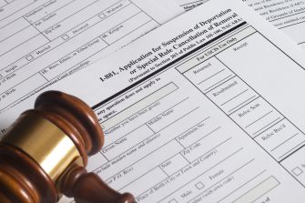 A gavel next to immigration forms related to the suspension of deportation applications.