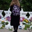A person stands in front of memorial stars honoring the victims of the Tree of Life synagogue shooting, surrounded by flowers and candles. A person stands in front of memorial stars honoring the victims of the Tree of Life synagogue shooting, surrounded by flowers and candles.