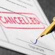 A close-up of a document with the word "CANCELLED" stamped in red, accompanied by a gold pen poised to sign. A close-up of a document with the word "CANCELLED" stamped in red, accompanied by a gold pen poised to sign.
