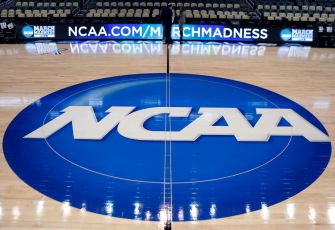NCAA logo on a basketball court during a March Madness event.