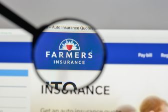 Farmers Insurance logo displayed on a computer screen under a magnifying glass.