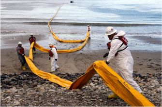 Workers in protective gear deploy oil spill containment booms along a beach affected by the 2015 Santa Barbara oil spill.