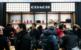 A crowded Coach store display featuring handbags and accessories.