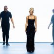 Kim Kardashian walking the runway in a black sequined gown during a fashion event. Kim Kardashian walking the runway in a black sequined gown during a fashion event.