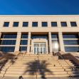 Modern courthouse with large stairs leading to the entrance, reflecting sunlight. Modern courthouse with large stairs leading to the entrance, reflecting sunlight.
