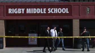 Exterior view of Rigby Middle School with authorities present and police tape surrounding the area after a shooting incident.