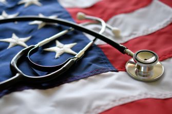 A stethoscope resting on an American flag, symbolizing healthcare and service members.