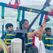 A woman and two children preparing for a parasailing excursion, with safety harnesses and life jackets on a boat in the ocean. A woman and two children preparing for a parasailing excursion, with safety harnesses and life jackets on a boat in the ocean.