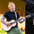 Ed Sheeran performing on stage with his guitar. Ed Sheeran performing on stage with his guitar.