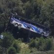 Aerial view of a blue bus that has overturned and is positioned against trees in a ravine following a crash in upstate New York. Aerial view of a blue bus that has overturned and is positioned against trees in a ravine following a crash in upstate New York.