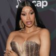Cardi B poses in a glamorous outfit at an event, showcasing her signature style and confidence. Cardi B poses in a glamorous outfit at an event, showcasing her signature style and confidence.