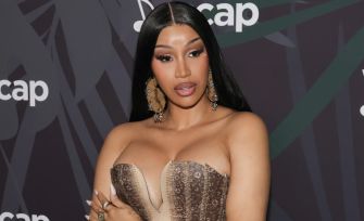 Cardi B poses in a glamorous outfit at an event, showcasing her signature style and confidence.