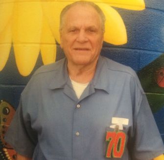Elderly man in prison uniform smiling against a colorful mural backdrop, symbolizing his release after 31 years for nonviolent marijuana charges.