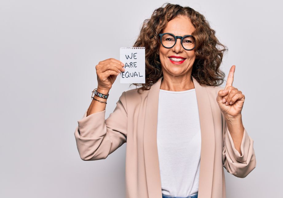 Old woman holding sign We are Equal