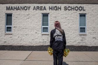 A cheerleader stands outside Mahanoy Area High School, reflecting on the implications of her social media post and the Supreme Court case regarding student free speech rights.