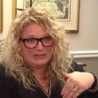 A woman with curly hair and glasses looks emotional while discussing a serious issue regarding her daughter’s safety at school. A woman with curly hair and glasses looks emotional while discussing a serious issue regarding her daughter’s safety at school.