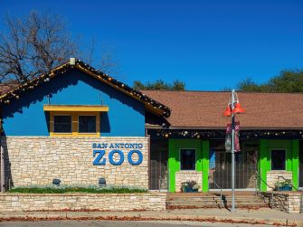 Exterior view of the San Antonio Zoo entrance on a clear day.